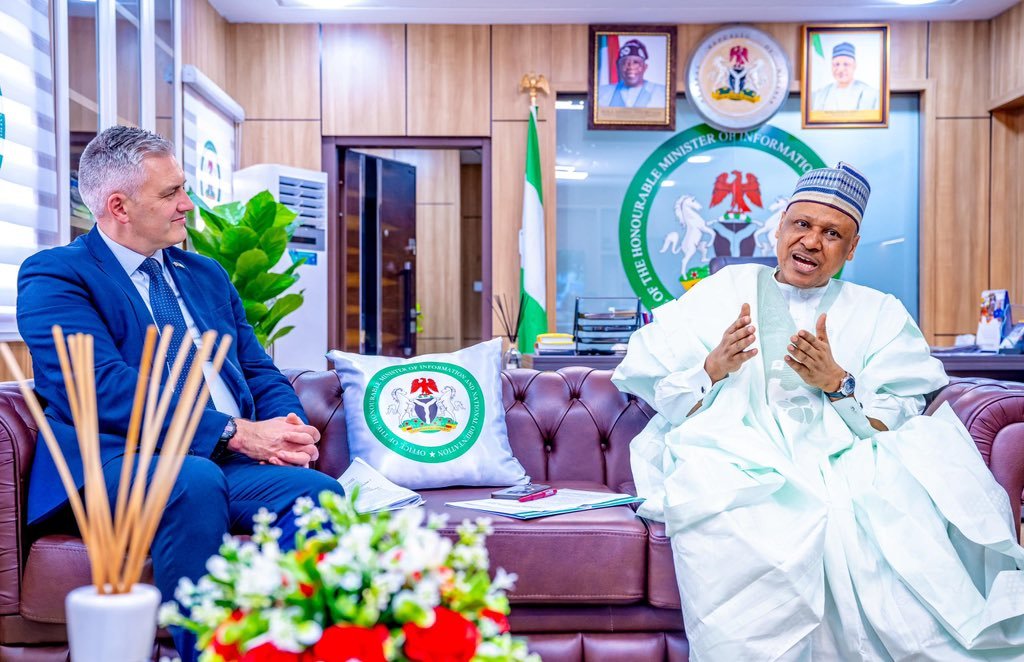 The Decisive Gesturing Shot Close-up of Minister Mohammed Idris speaking and gesturing with his hand during a meeting at the boardroom table with British officials.