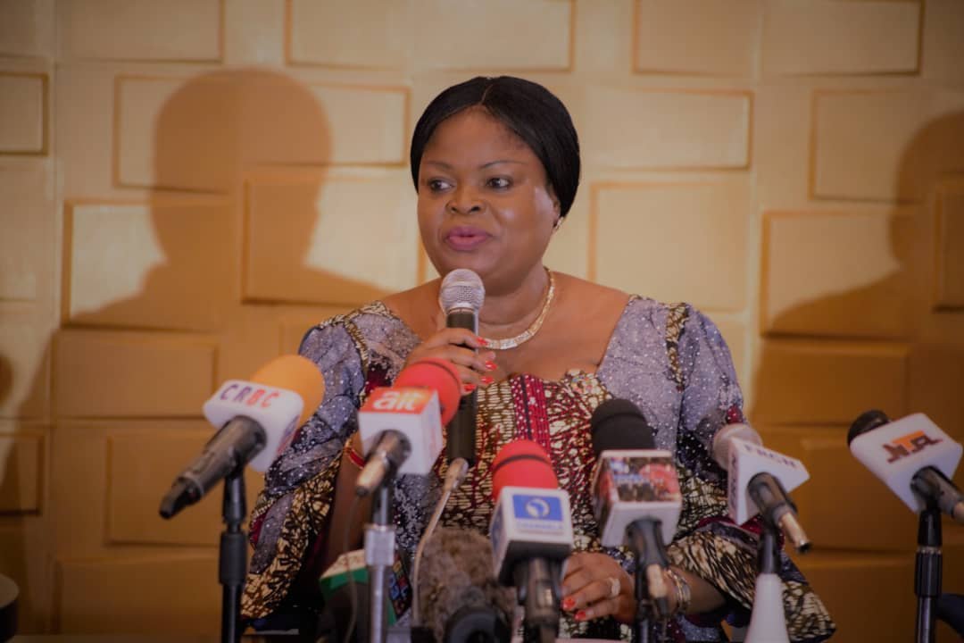 Princess Adejoke Orelope-Adefulire, SSAP-SDGs, speaking at a press conference in Nigeria, holding a microphone while surrounded by major news media mics including NTA, Channels TV, AIT, and FRCN